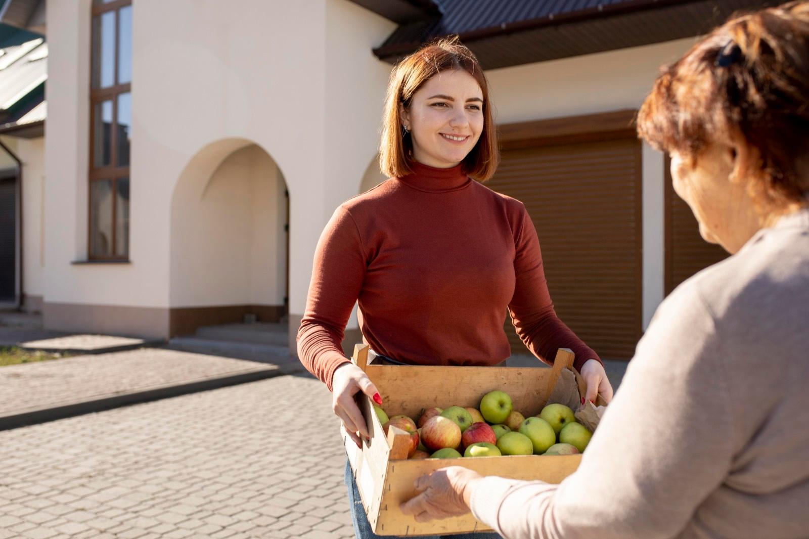 Helfer übergibt Einkäufe an Nachbarn